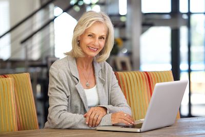 older woman sitting at desk with laptop