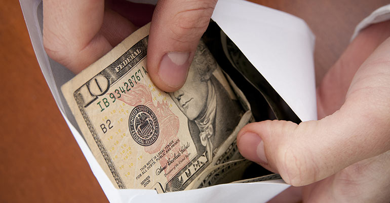 ten dollar bills being counted in envelope