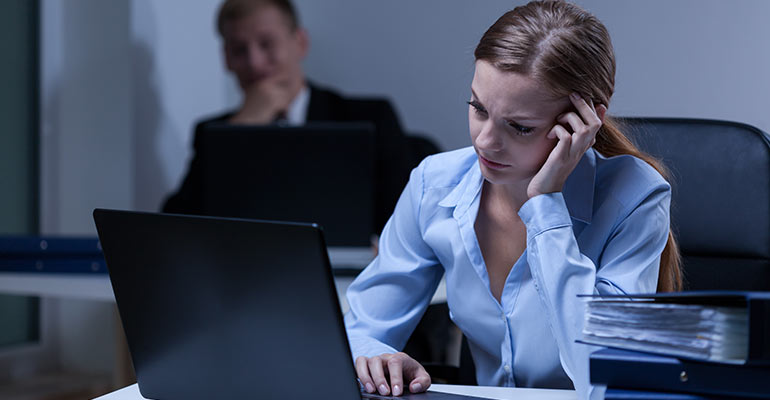 stressed woman sitting at her desk working
