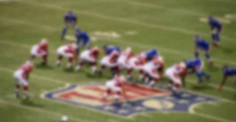 blurred photo of NFL logo and game