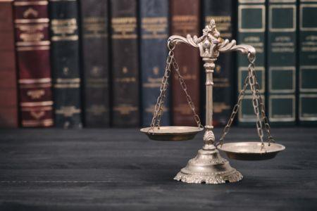 A scale sitting in top of legal textbooks in a law office