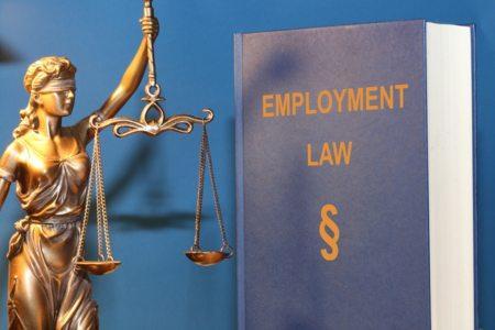 An employment law book next to the scales of justice