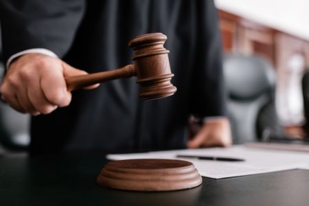 A judge banging a gavel to sentence an employer that illegally withdrew accommodations