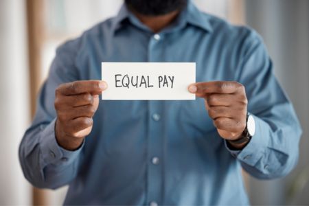 employee holding equal pay sign at work
