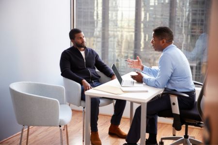 Client discussing a workplace matter with a lawyer across a desk