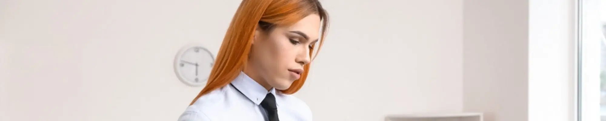 Transgender professional reviewing documents on a clipboard in an office