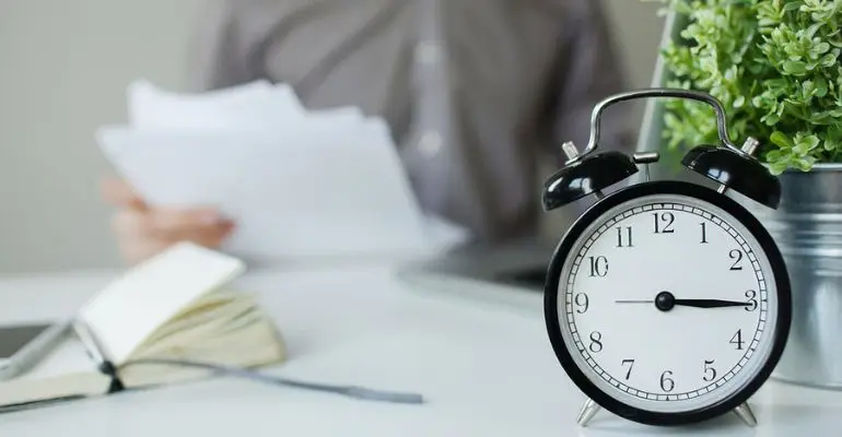 employee reviewing work schedule and hour-reduction paperwork at a desk
