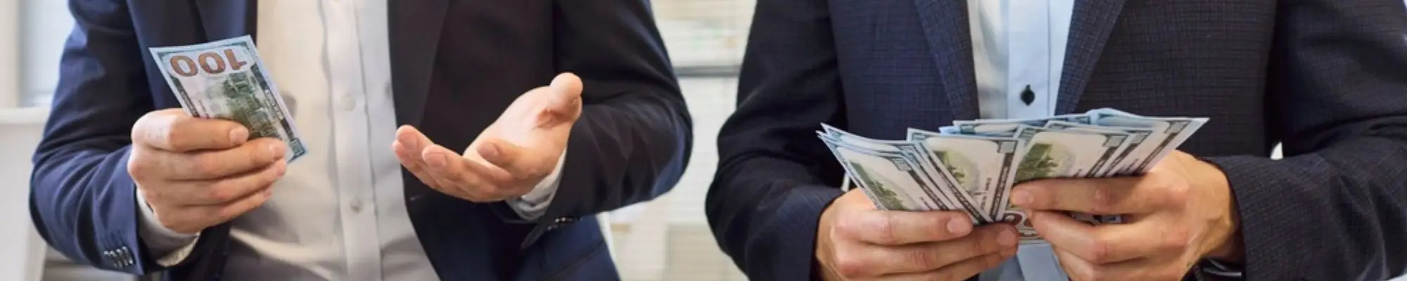 Two male professionals comparing different amounts of cash in an office
