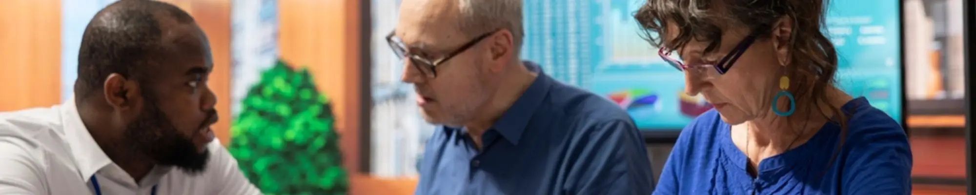 Older employees reviewing retirement plan documents with a financial professional
