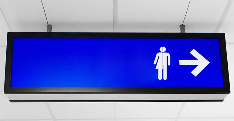 Sign attached to ceiling with female/male and arrow directing to go right
