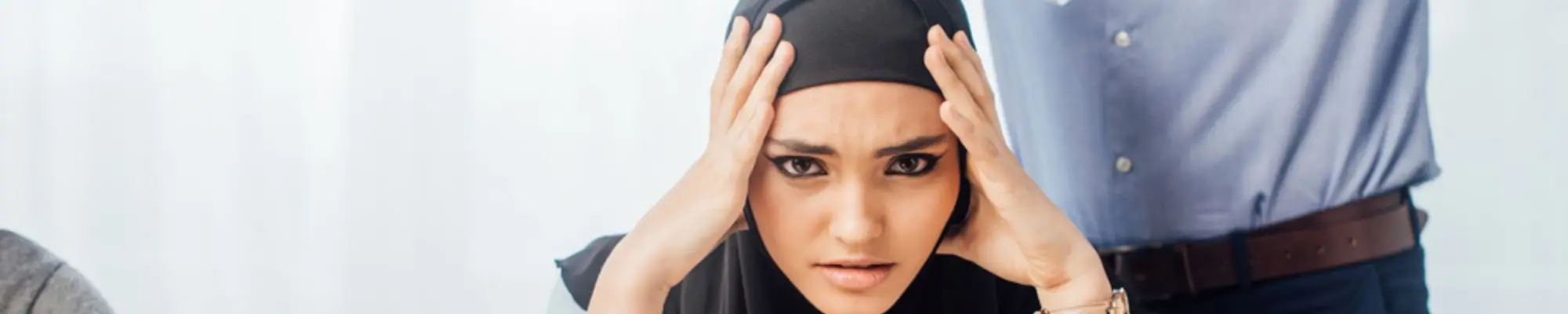 Muslim employee wearing a hijab looking stressed at her workplace