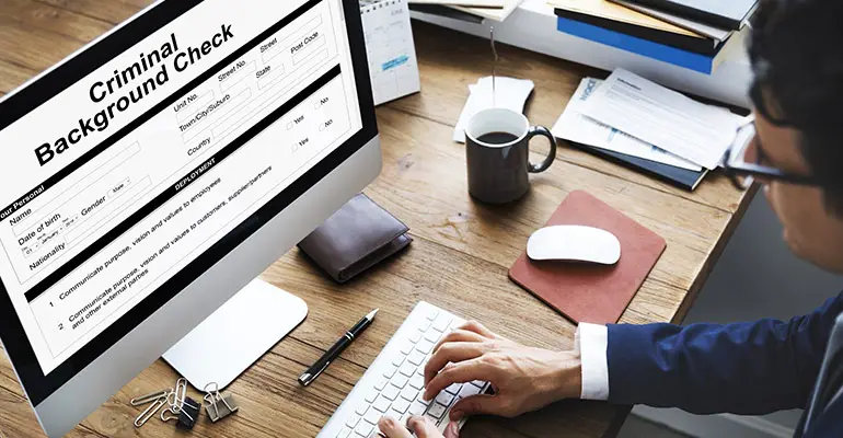 Man running a criminal background check on a computer