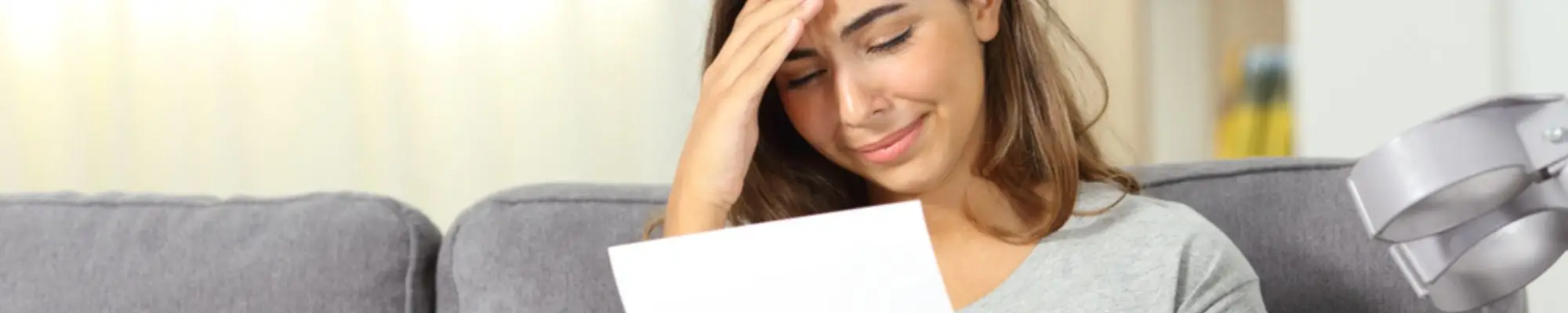 Injured woman looking upset while reading a letter at home