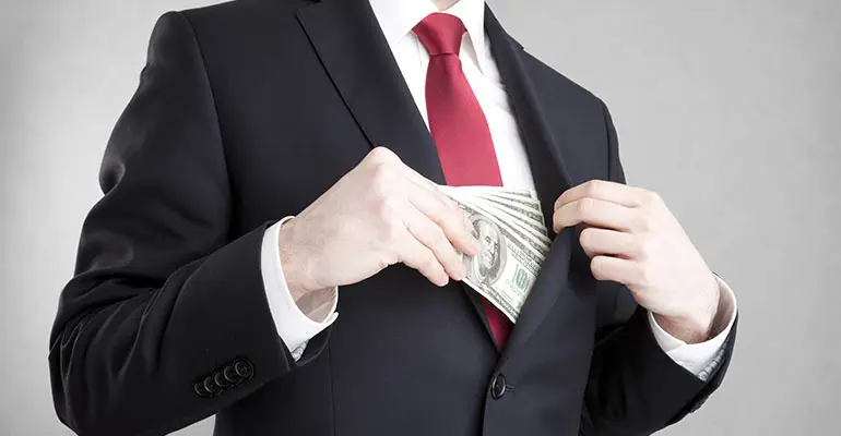 man wearing suite and taking stack of hundred dollar bills from jacket