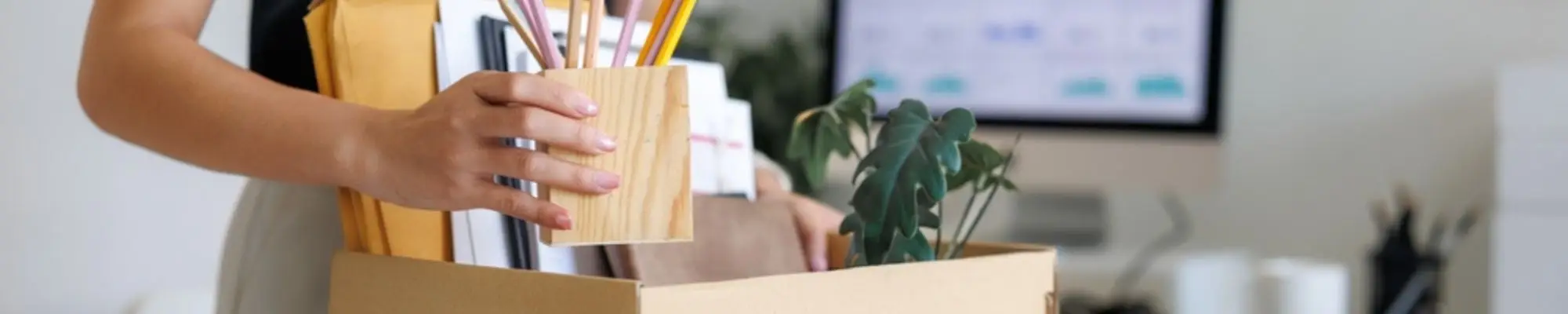Female employee packing her belongings into a box after leaving her job