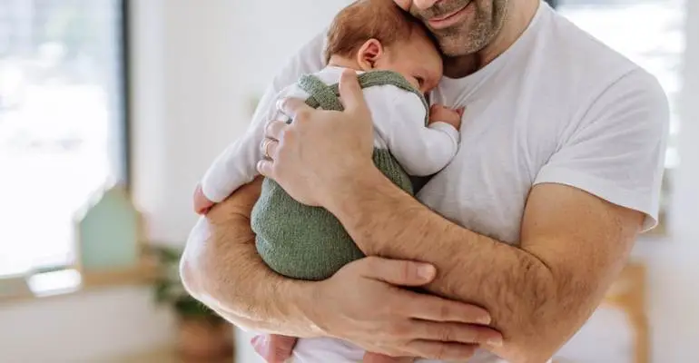 Father on paternity leave in Florida holding a baby