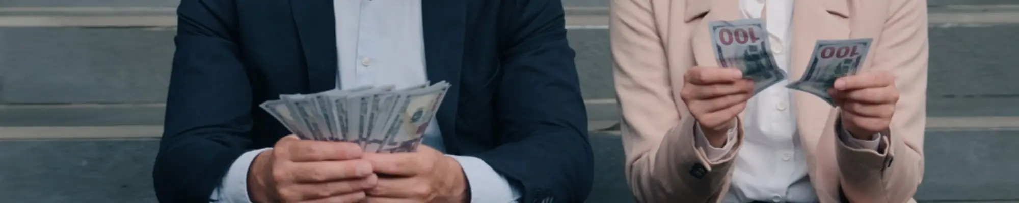 Male and female professionals comparing unequal amounts of money