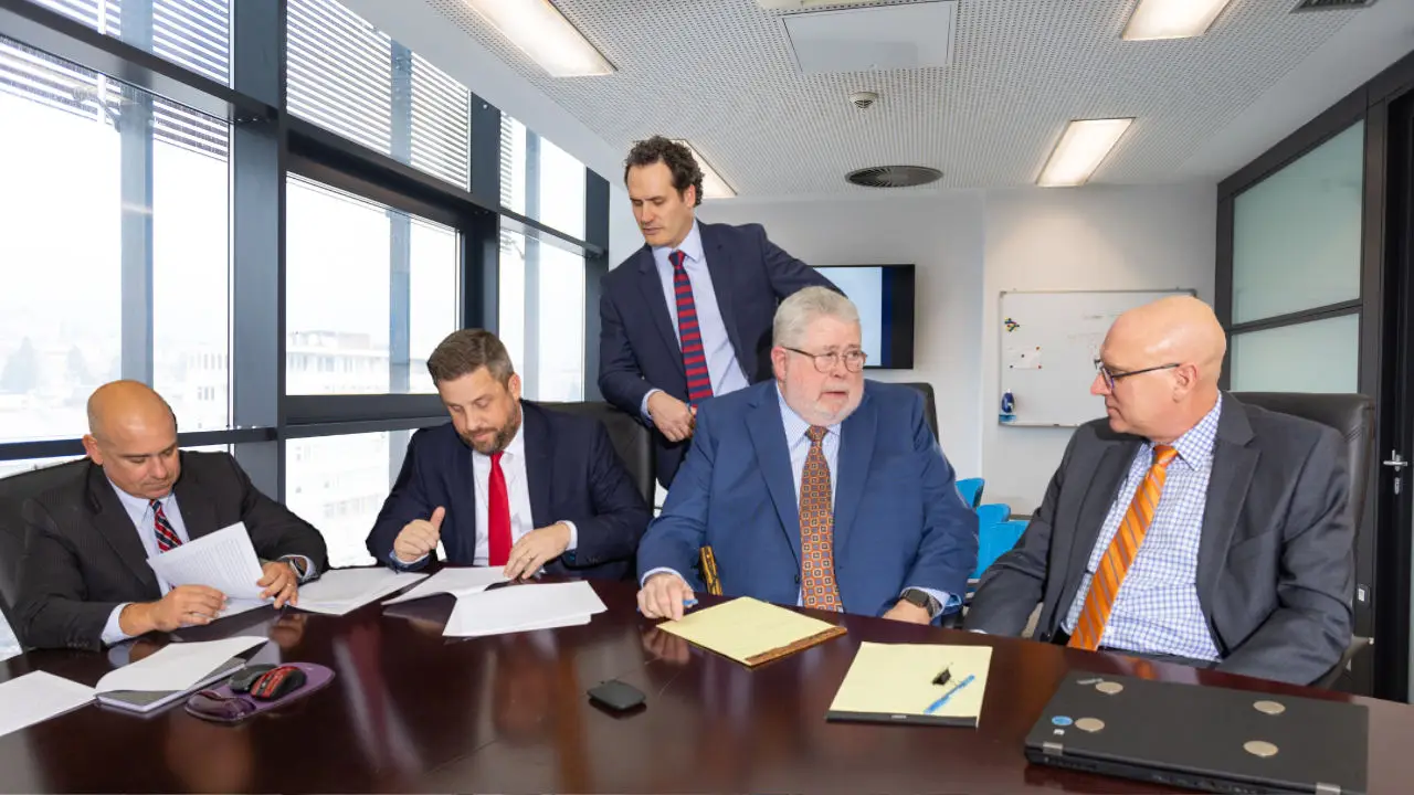 Lawyers seated around a table discussing a case