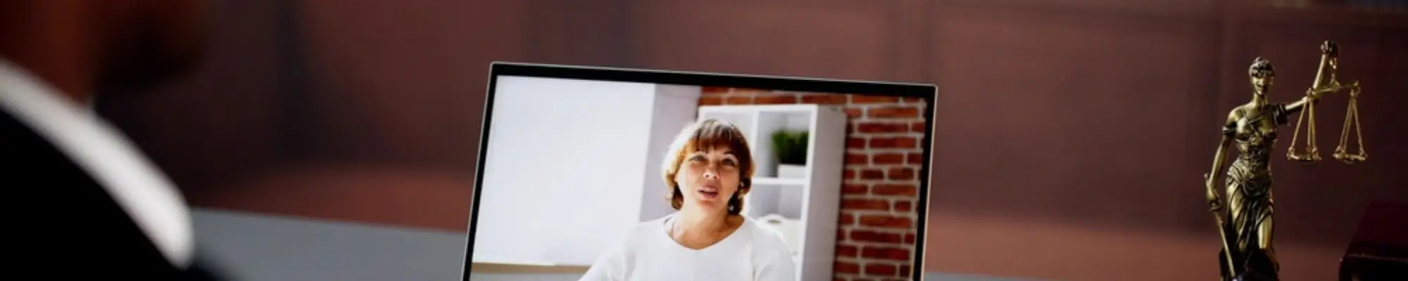 Attorney speaking with a client through a video call on a laptop