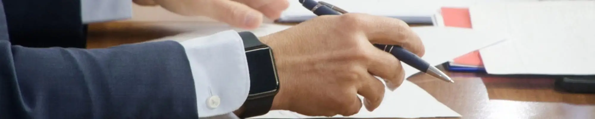 Business professional signing an employment contract at a desk