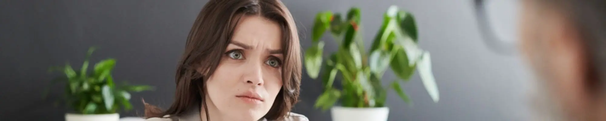 Concerned female employee speaking with a manager during an office meeting