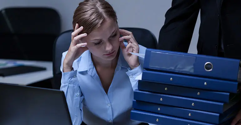 women looking at a stack of binders on her desk