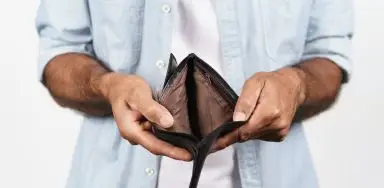 A man holding open an empty wallet