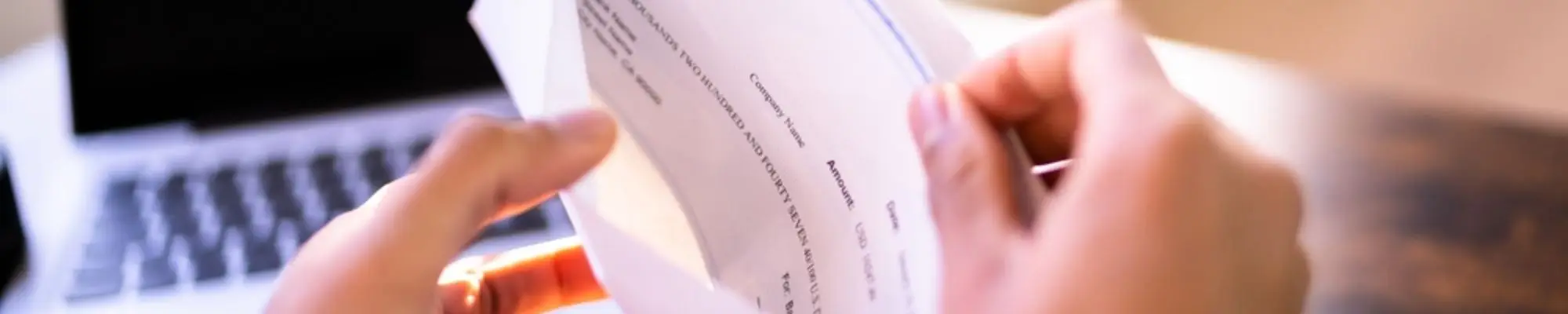 Employee opening an envelope containing a company paycheck